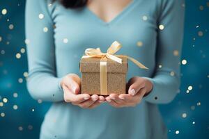 AI generated Woman hands holding elegant present gift box with golden ribbon over blue background with confetti photo