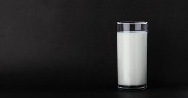 Glass of milk isolated on black background with copy space photo