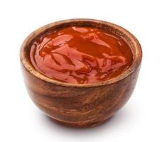 Ketchup in wooden bowl on white background photo