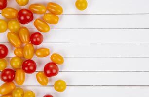 Colorful cherry tomatoes on white table, top view. photo