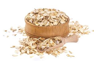 Oat flakes in wooden bowl isolated on white background photo