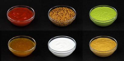 Different sauces isolated on black background photo