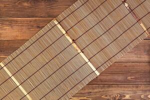 Bamboo mat for sushi on wooden background. photo