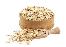 Oat flakes in wooden bowl isolated on white background photo