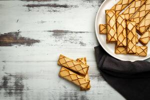 Sfogliatine, an Italian puff pastry with glaze on a plate on white background, top view photo