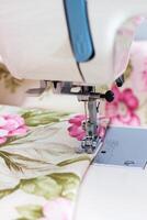 Modern sewing machine part with item of clothing photo