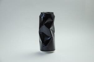 Crumpled aluminum black can on light background photo