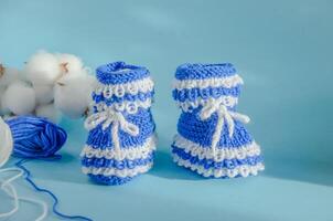 knitted blue booties socks with balls of thread for knitting photo