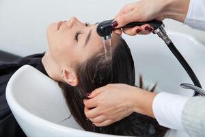 photo of a European girl with long and beautiful brunette hair at the beauty salon. Shiny and healthy hair.