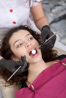 joven hembra paciente con bonito sonrisa examinando dental inspección a dentista clínica. sano dientes y medicamento, estomatología concepto foto