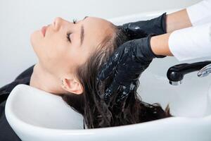 photo of a European girl with long and beautiful brunette hair at the beauty salon. Shiny and healthy hair.