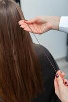 photo of a European girl with long and beautiful brunette hair at the beauty salon. Shiny and healthy hair.