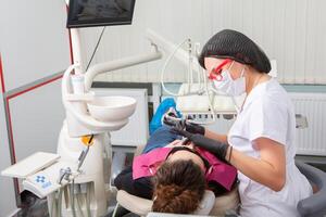 Woman having dental examination in stomatology clinic Treatment of caries, modern medicine. photo