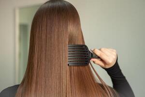 photo of a European girl with long and beautiful brunette hair at the beauty salon. Shiny and healthy hair.