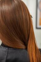 photo of a European girl with long and beautiful brunette hair at the beauty salon. Shiny and healthy hair.