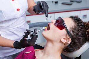 mujer teniendo dental examen en estomatología clínica tratamiento de caries, moderno medicamento. foto