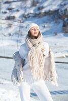 retrato de un hermosa joven mujer en blanco invierno ropa en naturaleza foto