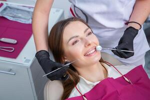 hermosa mujer con sano Derecho blanco dientes sentado a dental silla con abierto boca durante un dental procedimiento. dental clínica. estomatología foto