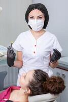 Dentist examining patient teeth in dental clinic. Dentistry and healthcare. Dentist holding dental tools in her hands. photo