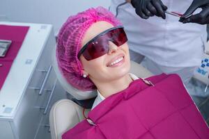 Young Female patient with pretty smile examining dental inspection at dentist clinic. Healthy teeth and medicine, stomatology concept photo