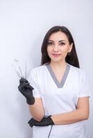 Dentist examining patient teeth in dental clinic. Dentistry and healthcare. Dentist holding dental tools in her hands. photo