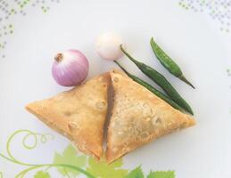 un samosa es un frito Pastelería desde sur Asia ese es lleno con sabroso ingredientes incluso guisantes, cerdo, pez, cebollas, o picante papas. además llamado shingara. foto