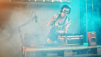 Musical specialist mixing records at turntables on stage, playing techno music at modern nightclub party. Woman mixer using bass key to create cool club performance. Handheld shot. photo