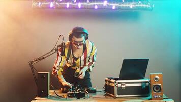 soñoliento artista Bebiendo café para energía, bostezando mientras ella mezclas moderno registros para techno club fiesta. DJ ejecutante sensación cansado después mezcla disco sonidos y melodías trípode disparo. foto