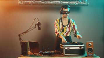 Talented disc jockey using vinyl to mix music at turntables, creating remix of modern records at electronic instrument. Mixing with audio control panel on nightclub stage. Tripod shot. photo