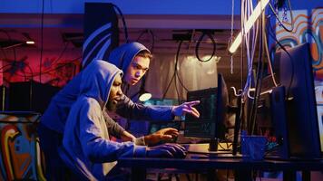 Hackers discussing how to best take advantage of security breach after gaining unauthorized access to system. Cybercriminals in secret hideout hacking network to steal government data photo