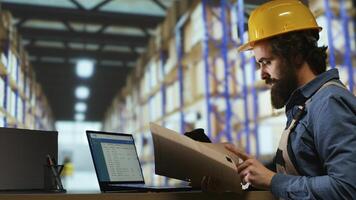 Shipping manager for operations verifies cargo details on files, ensuring right information for merchandise shipment and delivery. Staff member examines shipment tags at trade facility. photo