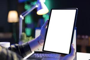Closeup of an individual vertically holding digital device with blank white screen display. A person grasping electronic tablet showing isolated chromakey mockup template. photo