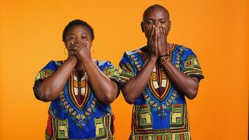 African american people doing three wise monkeys sign, covering their eyes, mouth and ears. Ethnic married couple advertising symbol to dont hear, speak or see bad evil things. photo