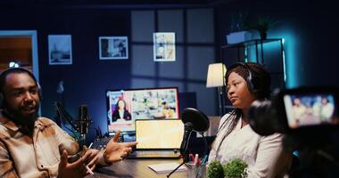 African american influencers in studio using high tech camera for internet show production on livestreaming channel. Vloggers partners doing podcasting session with professional video gear photo