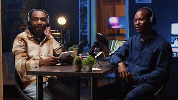 Podcast journalist fist bumping guest, ready to start listening to his interesting story while viewers watch from home. Host greeting african american man invited in studio to share facts photo