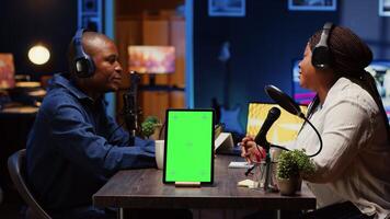 Green screen tablet in front of show host recording podcast, enjoying cup of coffee and nice conversation with guest. Mockup device in professional studio used for podcasting live session with woman photo