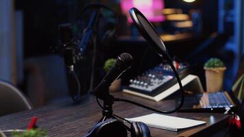 Close up shot of specialized radio microphone used in home personal studio by dj to record internet show guests. Professional audio devices in empty living room used for producing internet show photo