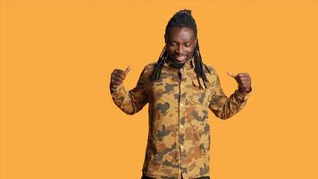 African american guy stretching and moving around on camera, doing fitness exercise to lose muscle tension. Fit athletic person feeling confident and positive over orange background. photo