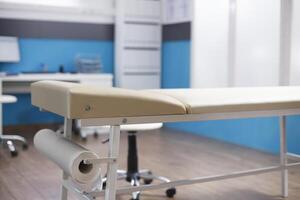 In a vacant doctor office, an examination bed is waiting for a patient consultation. An empty hospital room with no one inside and no medical equipment. Health care services. photo