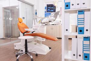 Interior of stomatology orthodontic hospital office with nobody in it ready for dental surgery equipped with modern dentistry tooth instruments. Medical room with teeth xray images on display photo