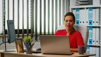 negocio mujer teniendo en línea reunión sentado en moderno lugar de trabajo. persona de libre dedicación trabajando con negocio remotamente equipo que se discute chateando teniendo virtual en línea conferencia, seminario web utilizando Internet tecnología foto