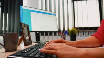 mujer dedos trabajando en un computadora teclado en moderno oficina habitación foto