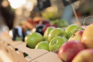 Natural organic food and health. Close up of fresh ripe green apples at farmers market, selective focus. Cardboard boxes full of various local seasonal fruits and vegetables on greenmarket stall photo