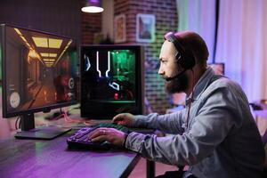 Pro gamer competing in intense online multiplayer videogame, streaming live from vibrant living room with rgb lights. Man using gaming computer and headphones for immersive experience photo