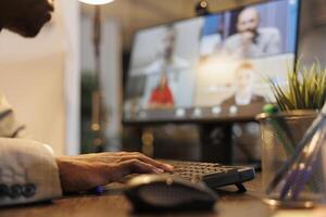 Entrepreneur discussing marketing statistics with remote coworkers during online videocall meeting conference. Diverse colleagues working over hours at company strategy in startup office photo