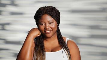 Sensual woman with radiant look posing in studio, creating skincare campaign for body acceptance. Positive cheerful beauty model advertising self love acting confident and uplifting. photo