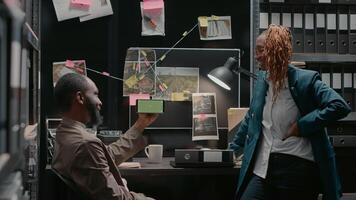 Law agents team analyzing phone with green screen, using isolated display in police evidence room. Two private detectives looking at smartphone with chroma key mockup copyspace. photo