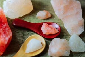 Close-up of Himalayan pink salt rock pieces on a wooden background photo