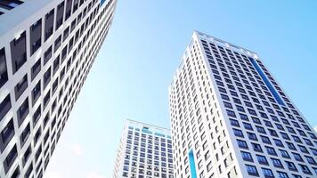 Bottom view of new residential high-rise buildings with blue sky. Urban environment. Frame. Newest residential complexes with an eco-friendly environment video