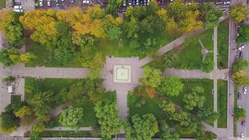 Top view of city park. Clip. Small park in city center with number of cars standing in parking lot. Ecological park in city in autumn video